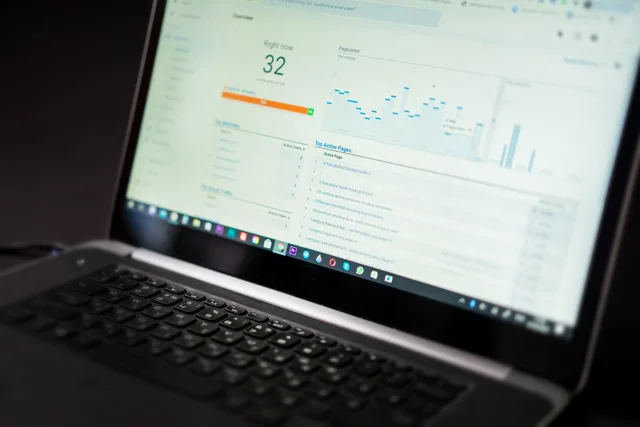 A laptop displaying an analytics dashboard with real-time data tracking and analysis tools. Five social listening signals to watch in 2027: AI visibility, sampling, quotes, skills and data law