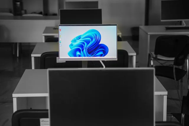 A contemporary office setup featuring computers on desks with modern flat screens. Service standards for social listening with thresholds someone can be held to