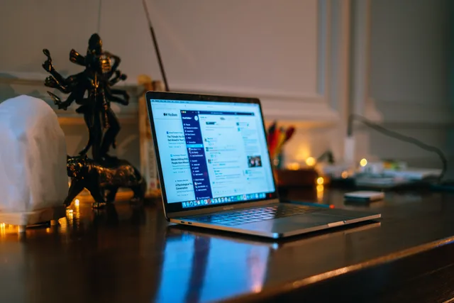 A cozy home office setup with a laptop on a wooden desk surrounded by warm lighting and decor. Choosing social listening tools and providers when coverage is only a claim